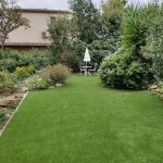 Terrasse en bois entourée de plantes méditerranéennes, illustrant une réalisation d'aménagement extérieur par un paysagiste local, combinant fonctionnalité et esthétique.