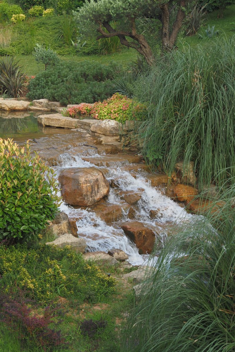 Entretien d'un ruisseau dans un jardin à La Crau, Var, illustrant les compétences d’un paysagiste dans la gestion des espaces d’eau pour un jardin harmonieux.